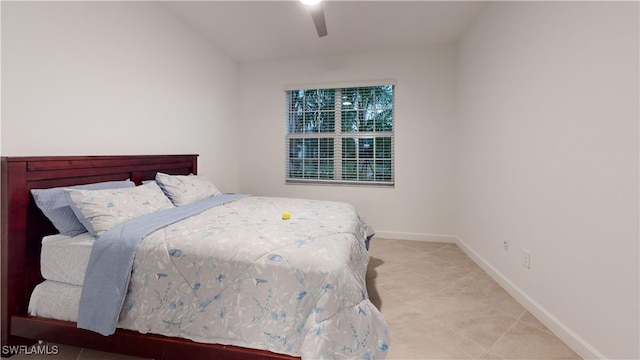 bedroom with ceiling fan, tile patterned flooring, and lofted ceiling