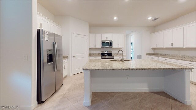 kitchen featuring white cabinets, a kitchen island with sink, sink, and appliances with stainless steel finishes