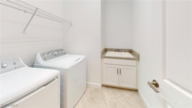 clothes washing area featuring light tile patterned flooring, sink, and washing machine and clothes dryer