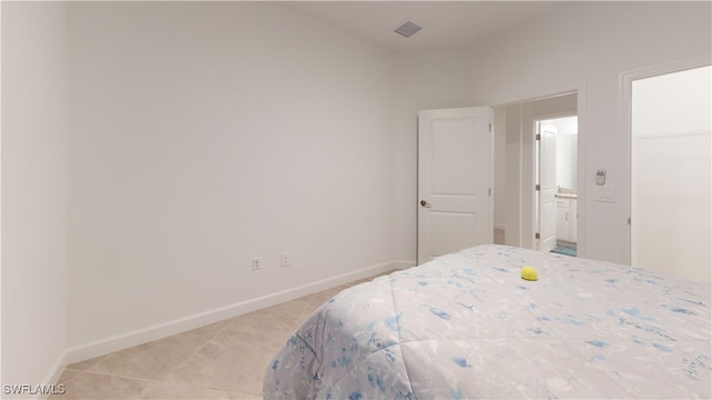 bedroom featuring light tile patterned floors, a spacious closet, and a closet