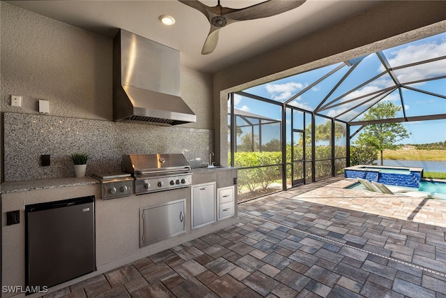 view of patio / terrace featuring ceiling fan, sink, grilling area, a swimming pool with hot tub, and glass enclosure