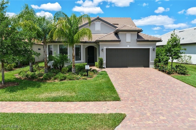 mediterranean / spanish house featuring a garage and a front lawn