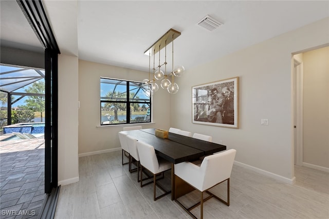 dining space featuring light hardwood / wood-style flooring and an inviting chandelier