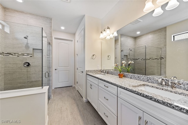 bathroom with vanity, an enclosed shower, and hardwood / wood-style flooring