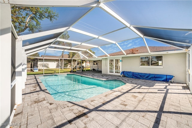 view of pool featuring glass enclosure, a patio area, and french doors