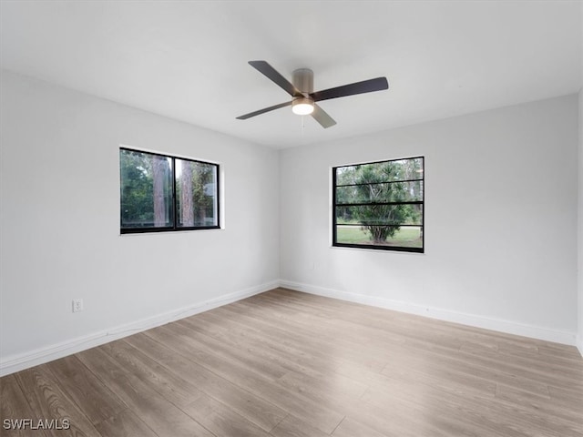 empty room with ceiling fan and light hardwood / wood-style flooring