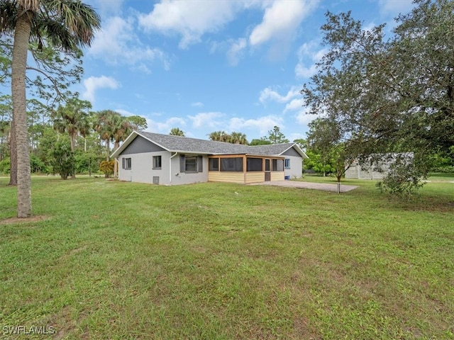 back of property featuring a yard and a sunroom