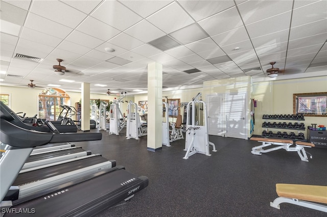 exercise room with a paneled ceiling and ceiling fan