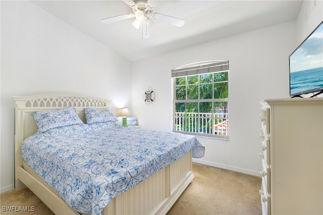 bedroom with ceiling fan, light colored carpet, and vaulted ceiling