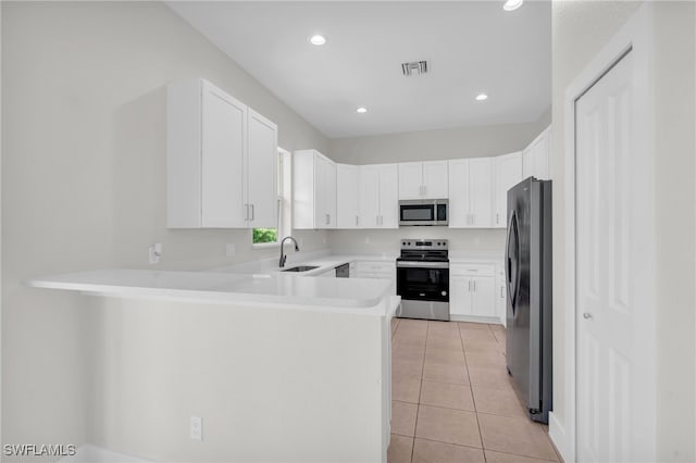 kitchen featuring white cabinets, light tile patterned floors, sink, kitchen peninsula, and stainless steel appliances