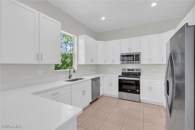 kitchen featuring sink, light tile patterned floors, stainless steel appliances, and white cabinets