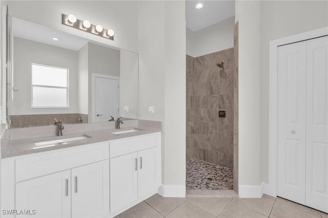 bathroom featuring vanity, tile patterned floors, and tiled shower