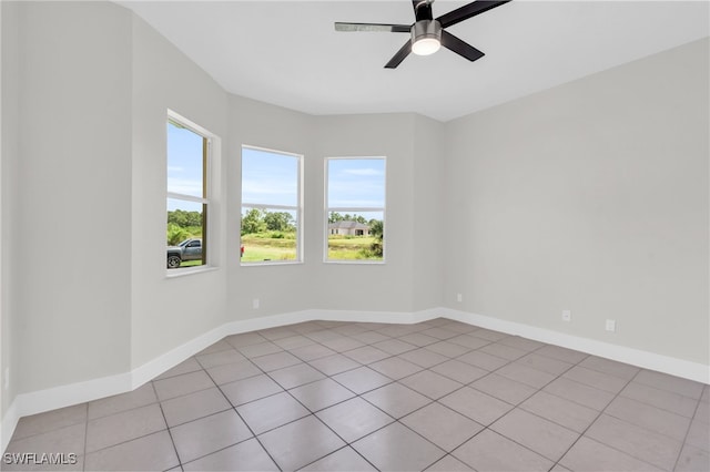 empty room with ceiling fan and light tile patterned floors