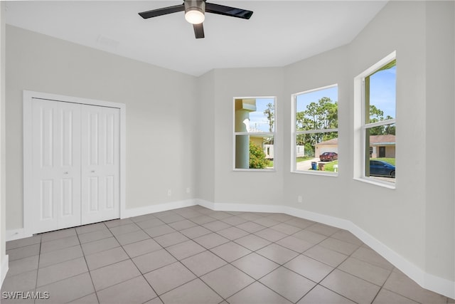 empty room with ceiling fan and light tile patterned flooring