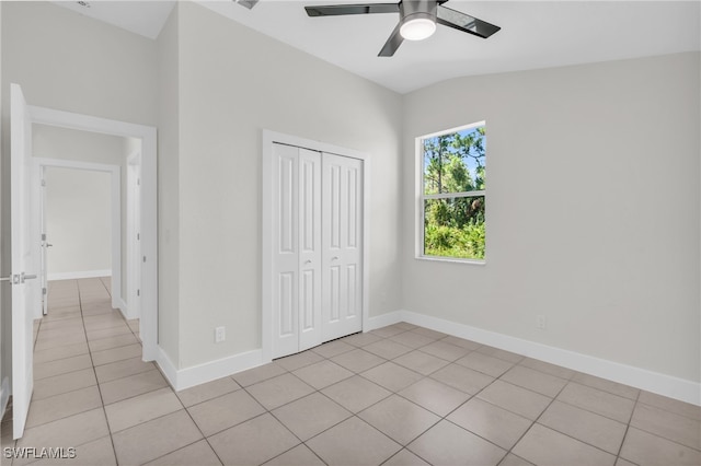 unfurnished bedroom with a closet, vaulted ceiling, ceiling fan, and light tile patterned floors