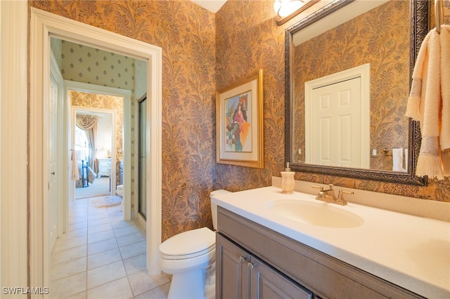 bathroom featuring walk in shower, tile patterned flooring, vanity, and toilet