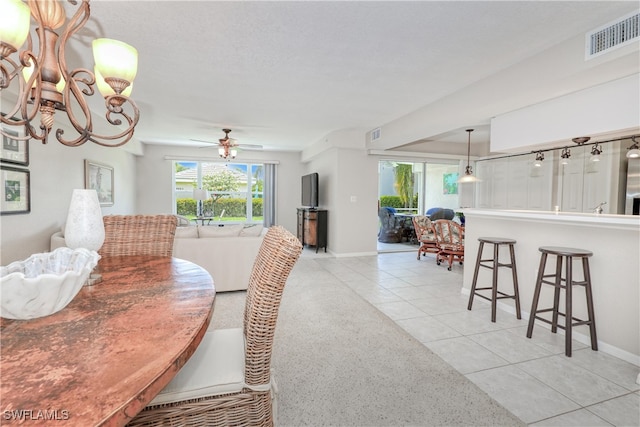 dining room with light tile patterned floors and ceiling fan with notable chandelier