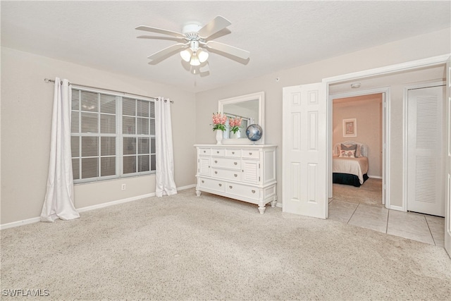 unfurnished bedroom with ceiling fan and light colored carpet