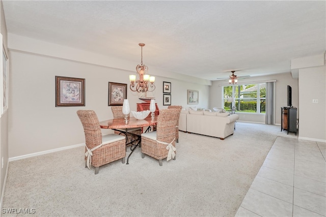 carpeted dining space featuring ceiling fan with notable chandelier