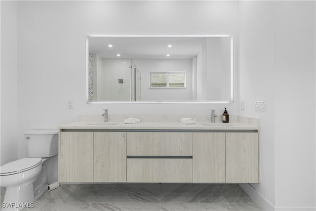 bathroom with vanity, toilet, and a shower with door