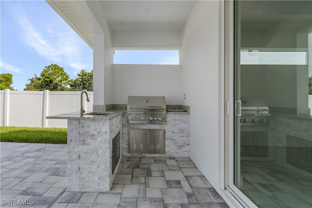 view of patio with a grill, sink, and exterior kitchen