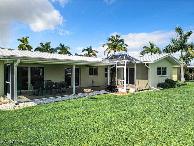 rear view of house with a yard, a lanai, and a patio area