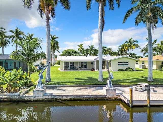 rear view of house featuring a yard and a water view