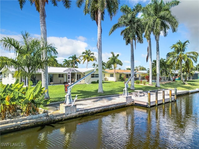 view of dock featuring a lawn and a water view