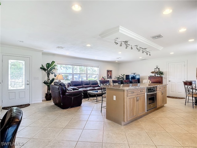 kitchen featuring a breakfast bar, stainless steel oven, a healthy amount of sunlight, and a center island