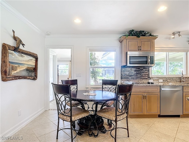 tiled dining room featuring sink and crown molding