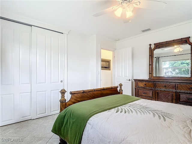 bedroom with ceiling fan, a closet, crown molding, and light tile patterned floors