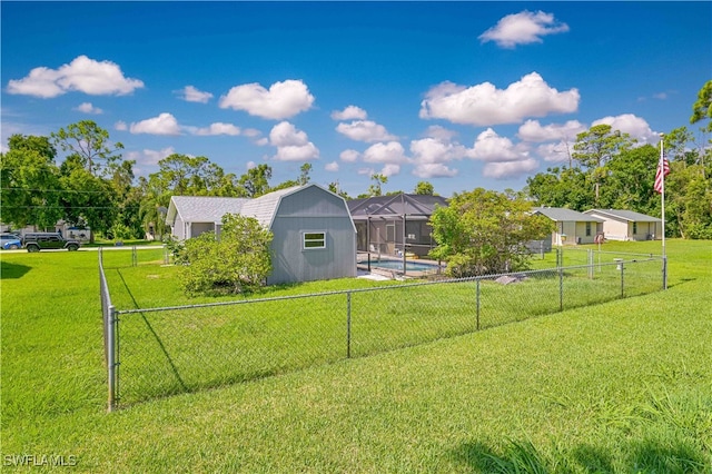 view of yard featuring a fenced in pool, a storage shed, and a lanai