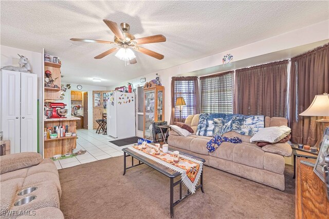 carpeted living room with ceiling fan and a textured ceiling