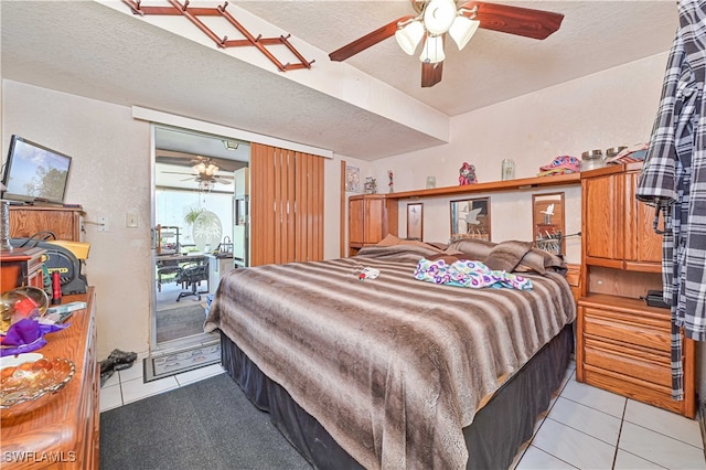 tiled bedroom featuring a textured ceiling and ceiling fan