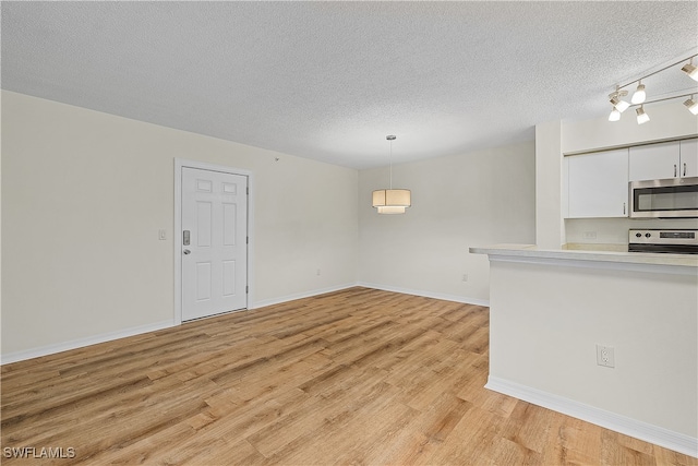 interior space with a textured ceiling and light wood-type flooring