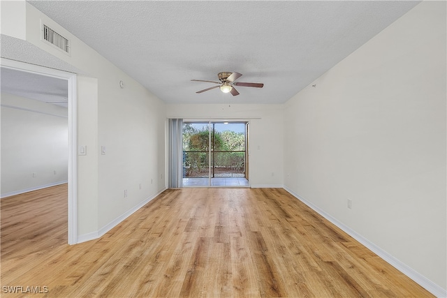 empty room featuring ceiling fan, light hardwood / wood-style floors, and a textured ceiling