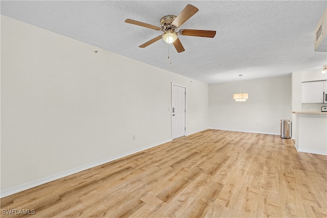 unfurnished living room with ceiling fan, a textured ceiling, and light hardwood / wood-style flooring