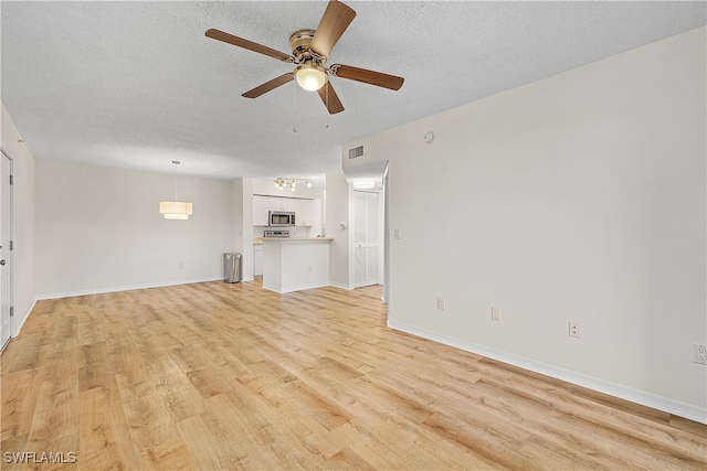 unfurnished living room with ceiling fan, a textured ceiling, and light wood-type flooring