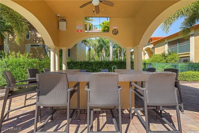 view of patio with ceiling fan and exterior bar