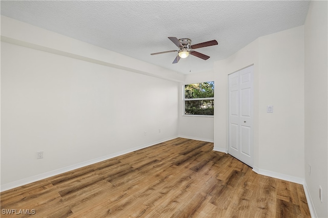 unfurnished room featuring wood-type flooring, ceiling fan, and a textured ceiling