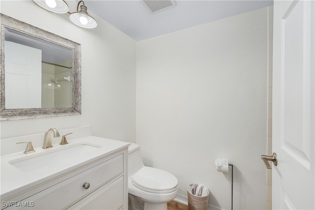 bathroom with vanity, toilet, and a shower