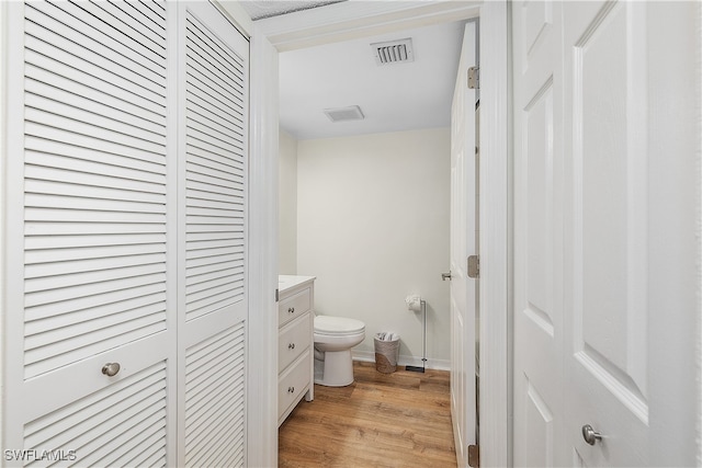 bathroom with vanity, wood-type flooring, and toilet