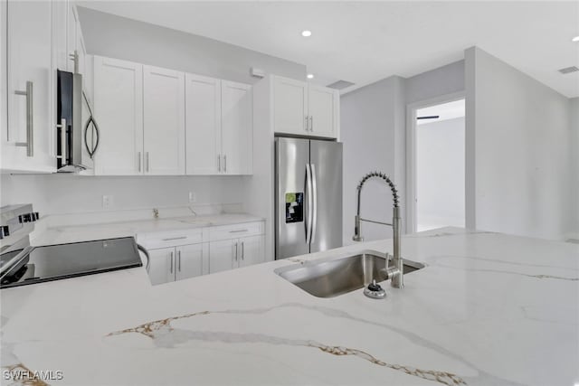 kitchen with white cabinetry, sink, stainless steel appliances, and light stone counters