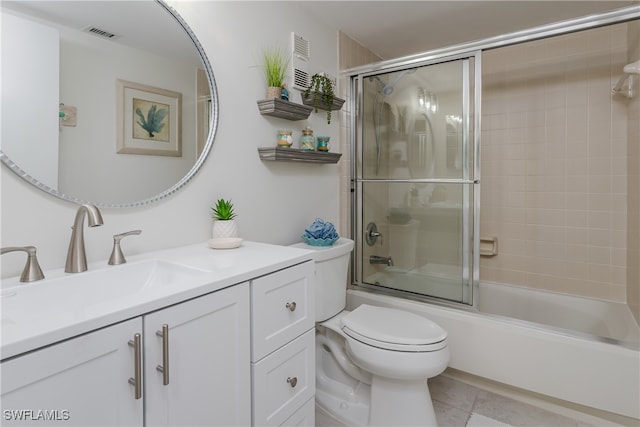 full bathroom featuring tile patterned flooring, shower / bath combination with glass door, vanity, and toilet