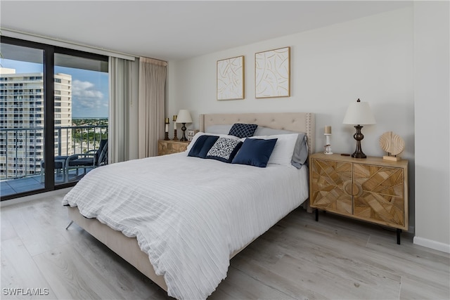 bedroom featuring wood-type flooring and access to outside