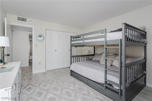 bedroom with light hardwood / wood-style flooring and a closet