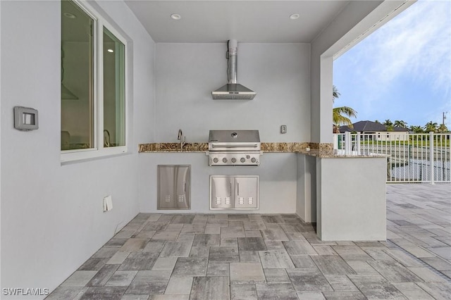 view of patio / terrace featuring exterior kitchen, area for grilling, fence, and a sink