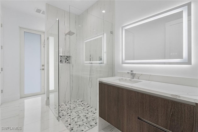 bathroom with a marble finish shower, visible vents, marble finish floor, and vanity