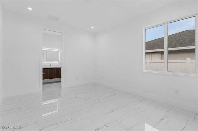 spare room with recessed lighting, baseboards, and marble finish floor