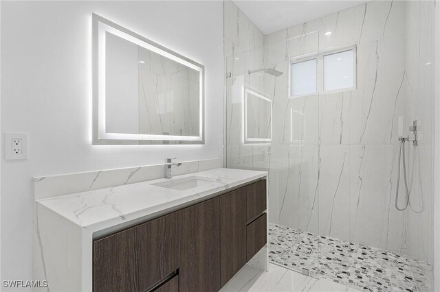 bathroom featuring a tile shower and vanity